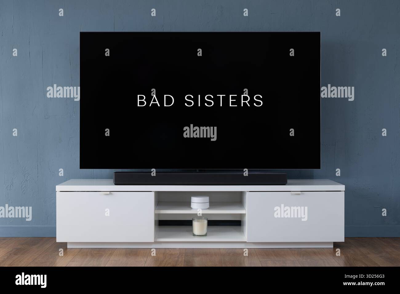 Un televisore OLED widescreen che mostra la scena introduttiva della serie TV Bad Sisters, visto in un salotto contemporaneo. Foto Stock