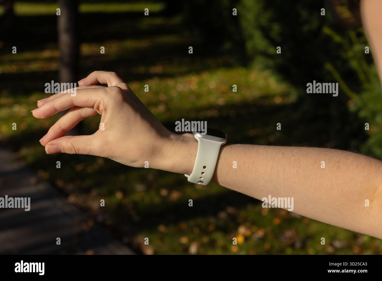 Poznan, Polonia - 24 settembre 2025: Primo piano del braccio di una persona che indossa un Apple Watch con una fascia bianca all'aperto, che mette in risalto lo stile di vita attivo Foto Stock