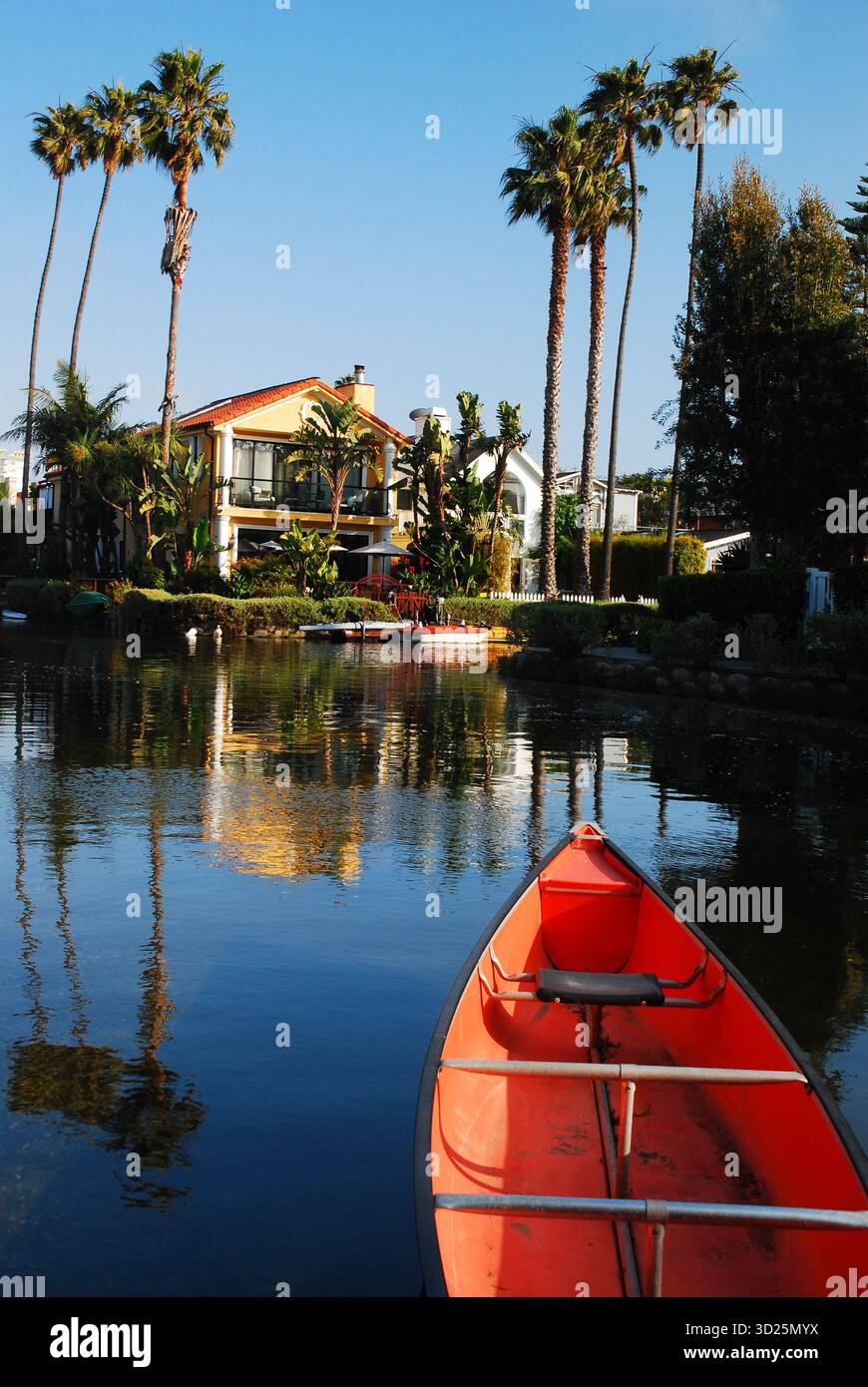 Una canoa rossa è legata alla costa lungo gli storici canali di Venice, California Foto Stock