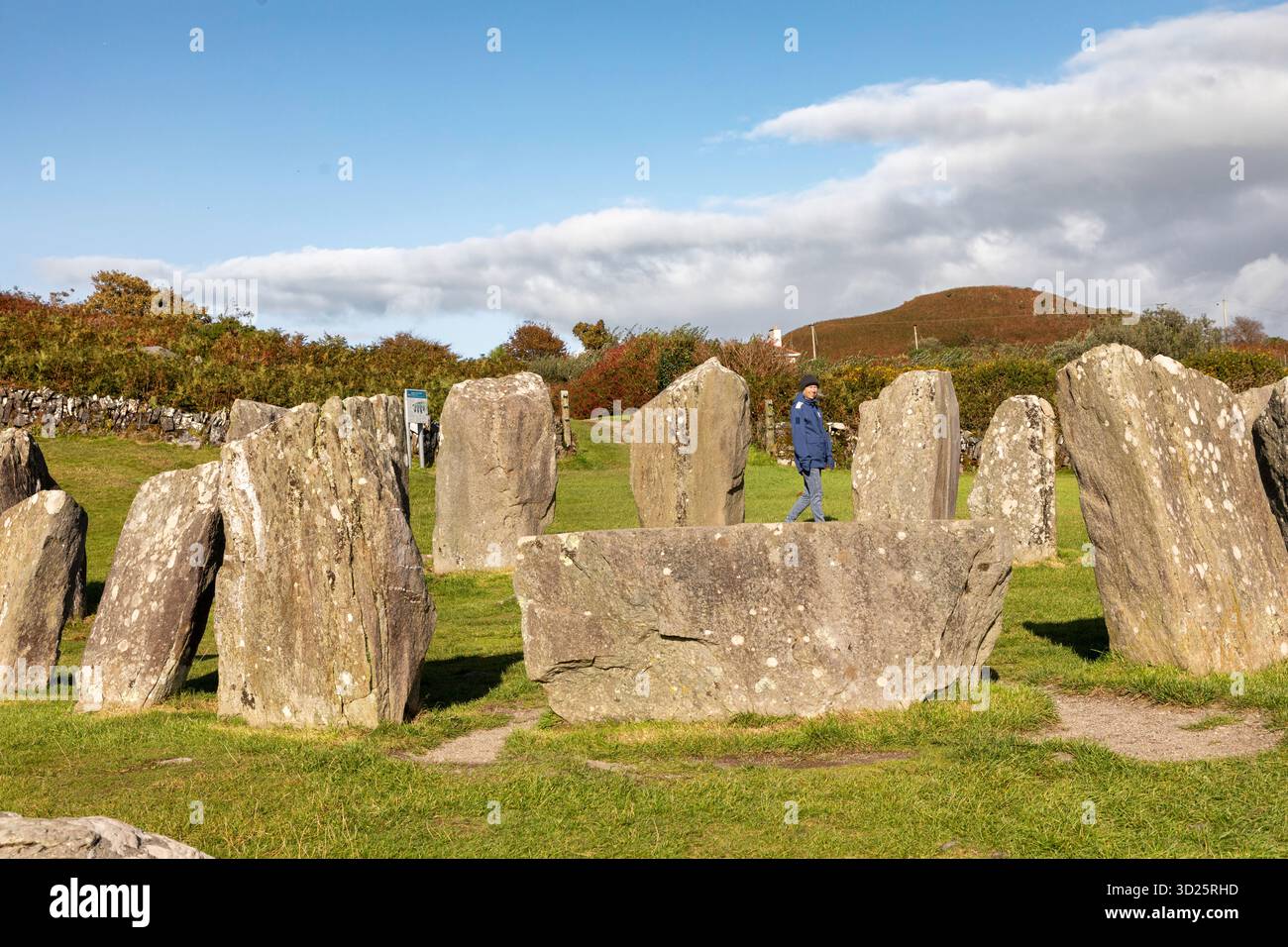 Un turista girovagerà intorno al cerchio di pietre di Drombeg   noto anche come l'altare del Druido  vicino a Glandore, Contea di Cork, Irlanda. Foto Stock