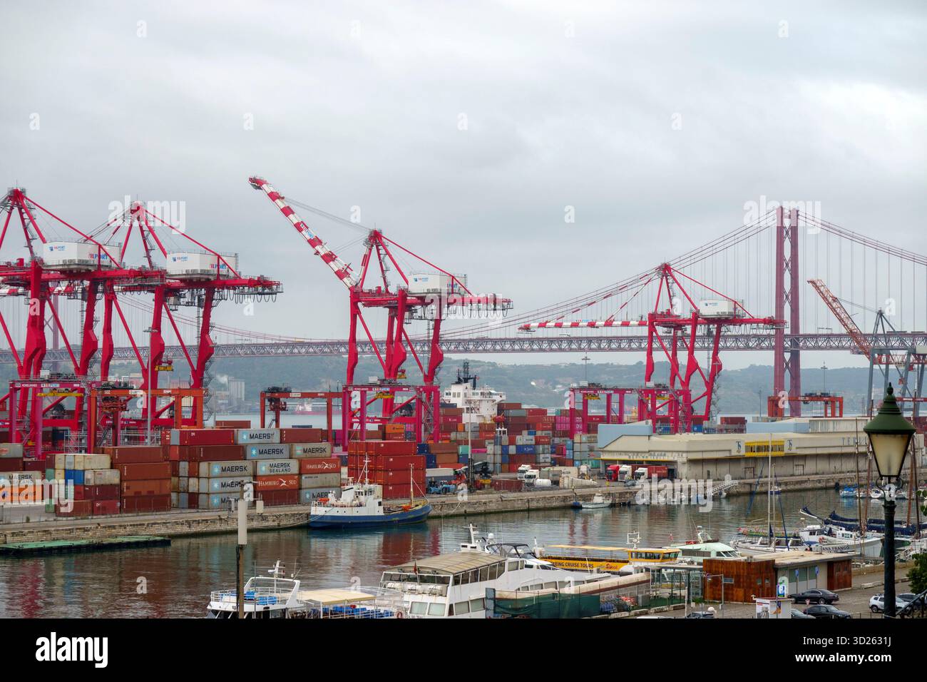Grande porto di spedizione con gru a cavalletto rosse e numerosi container impilati presso il porto di Lisbona, Portogallo, Europa Foto Stock