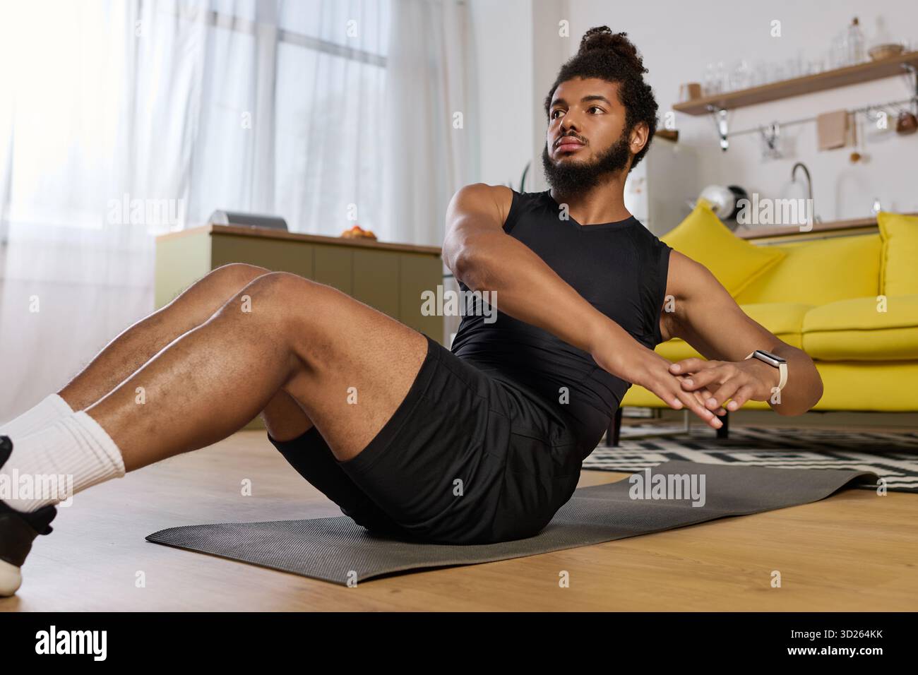 Bearded Black Man fa esercizi di base a casa su un tappetino da yoga, concentrato e determinato. Foto Stock