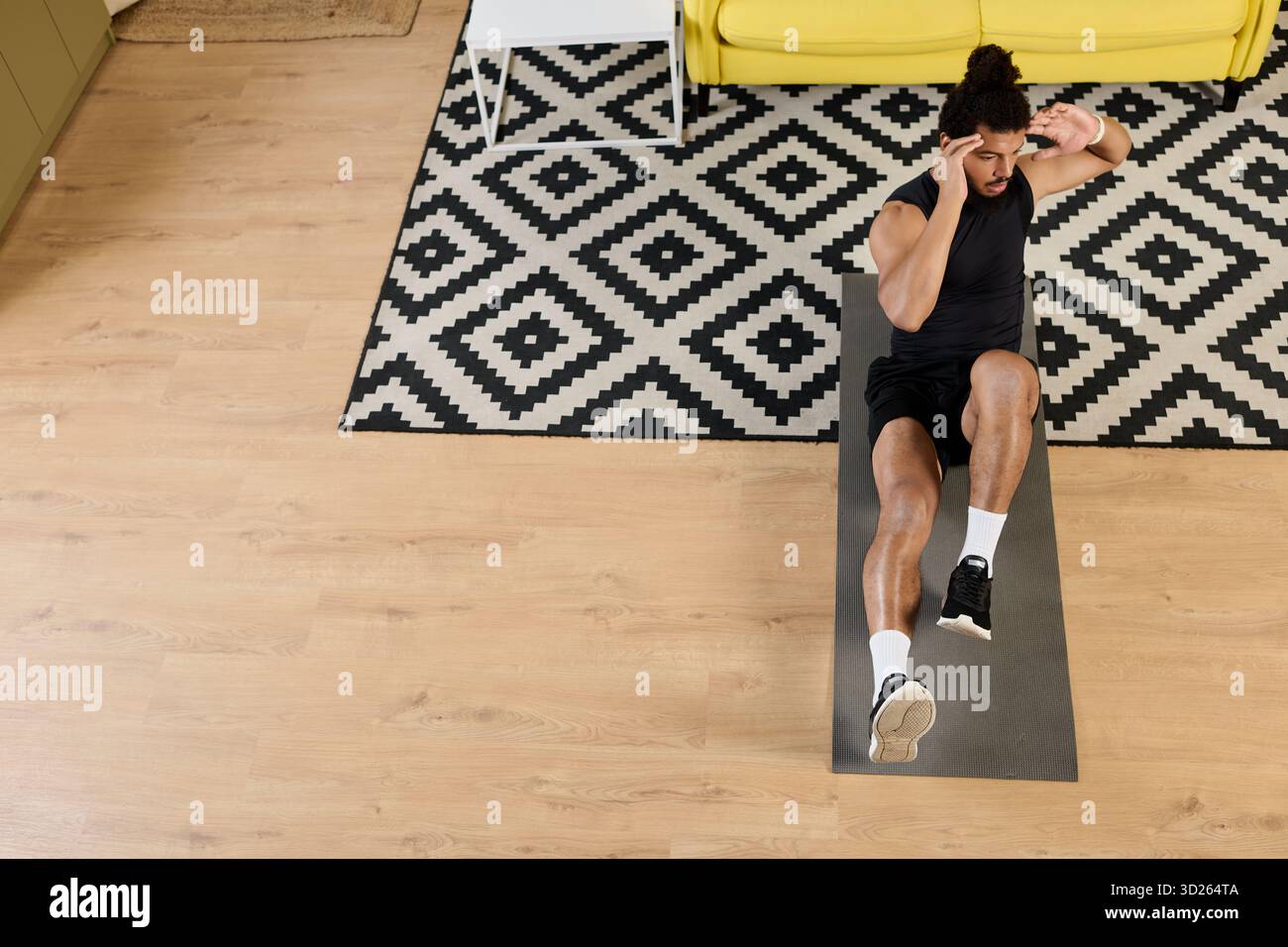 Un atletico esegue esercizi di base a casa pur mantenendo la concentrazione. Foto Stock