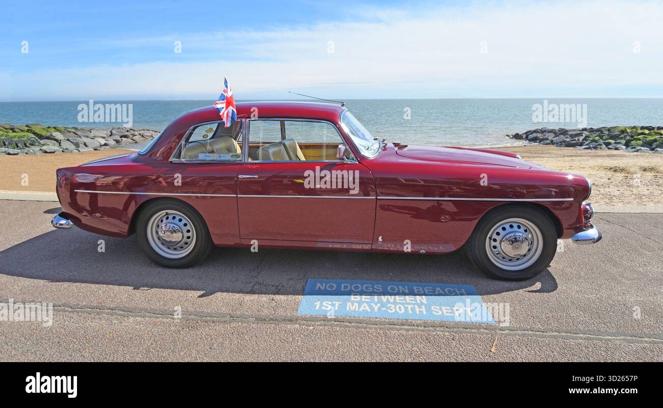 Auto Classic Red Bristol parcheggiata sul lungomare e sul mare sullo sfondo Foto Stock