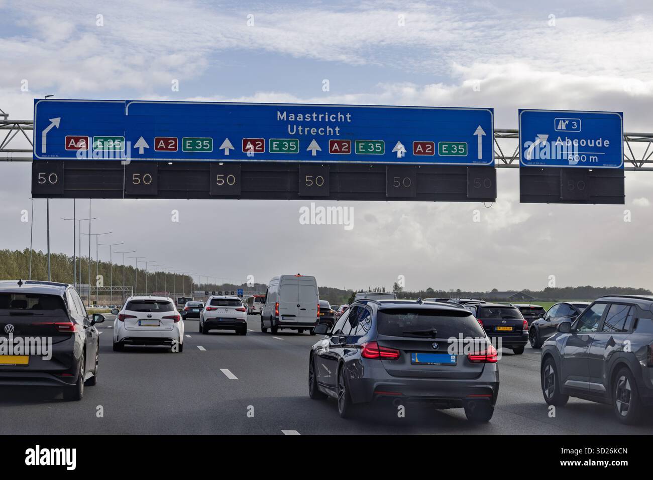 Un'autostrada olandese congestionata (A2) mostra un cartello blu che indica le indicazioni per Maastricht e Utrecht, con tutte le corsie limitate a 50 km/h spe Foto Stock