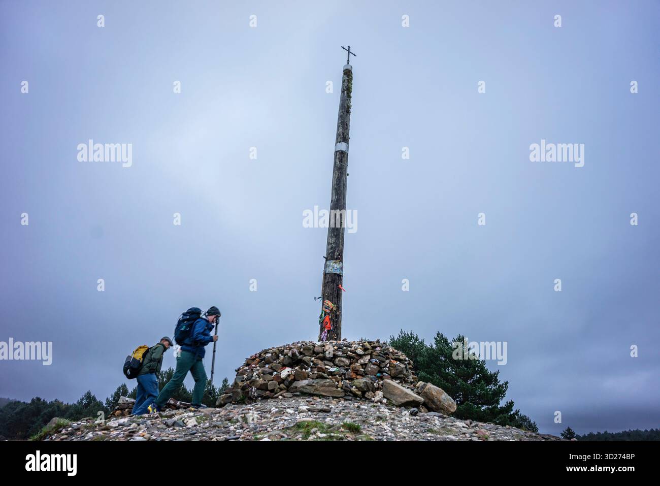 Pellegrini di Santiago a Cruz de ferro (Croce di ferro), collina di Foncebadón, regione di Bierzo, Castiglia e León, Spagna. Foto Stock