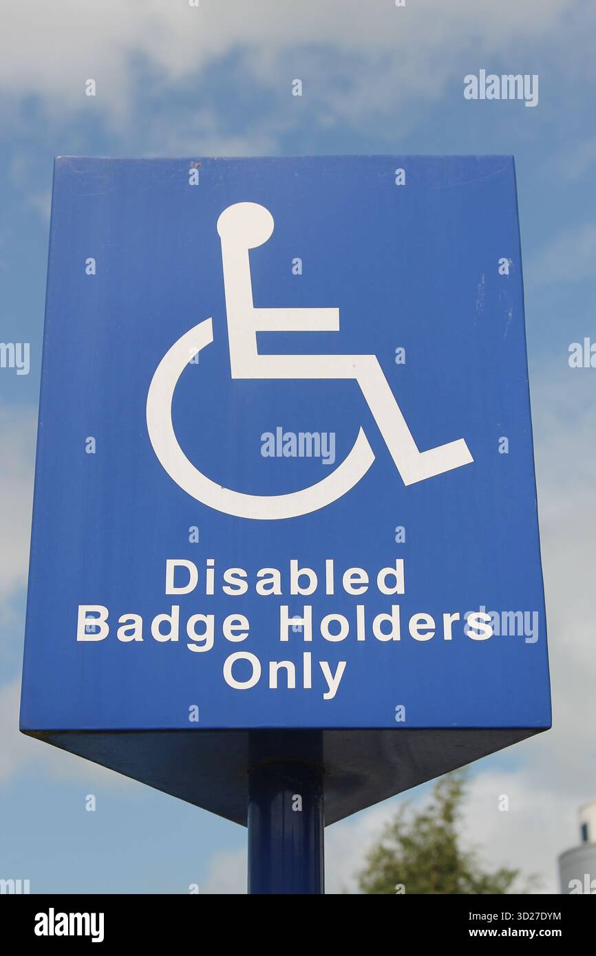 Un segno blu e bianco che mostra uno spazio riservato solo ai proprietari di badge blu disabili Foto Stock