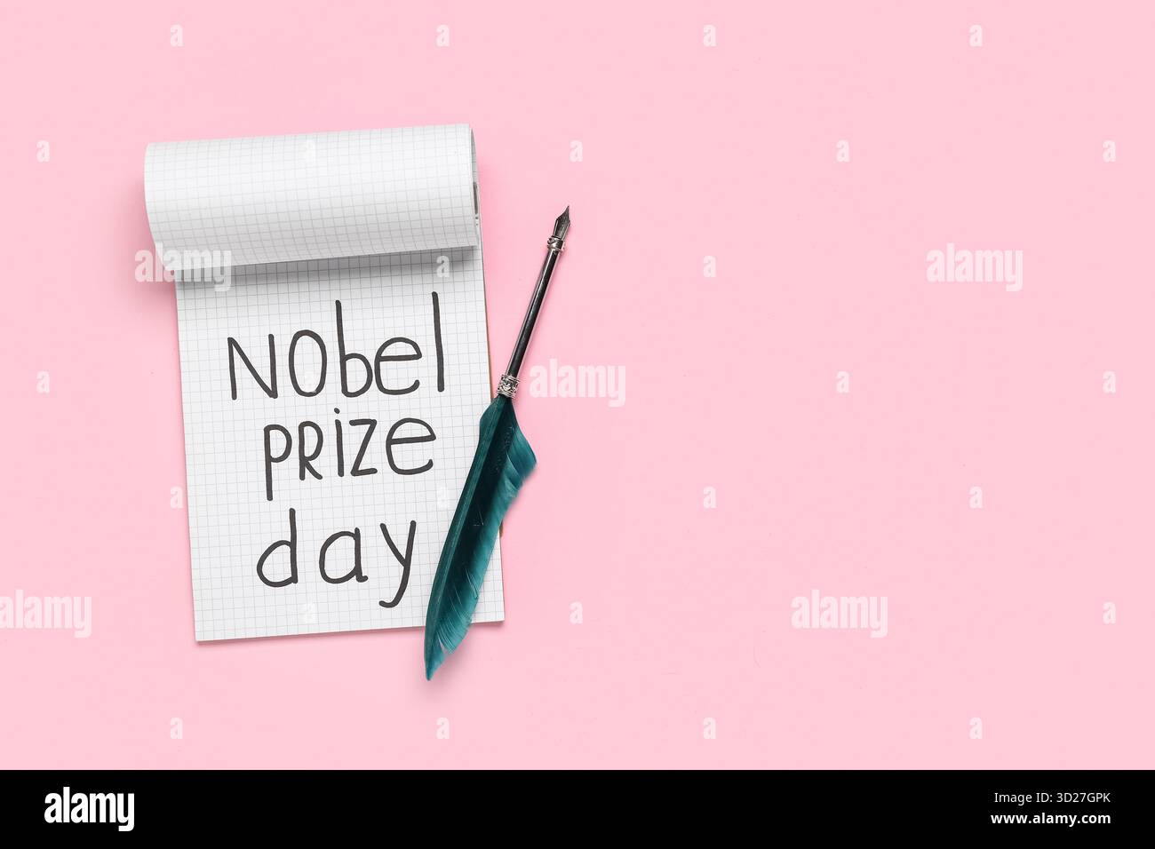 Quaderno con testo GIORNO PREMIO NOBEL e piuma su sfondo rosa. Celebrazione del giorno del premio Nobel Foto Stock