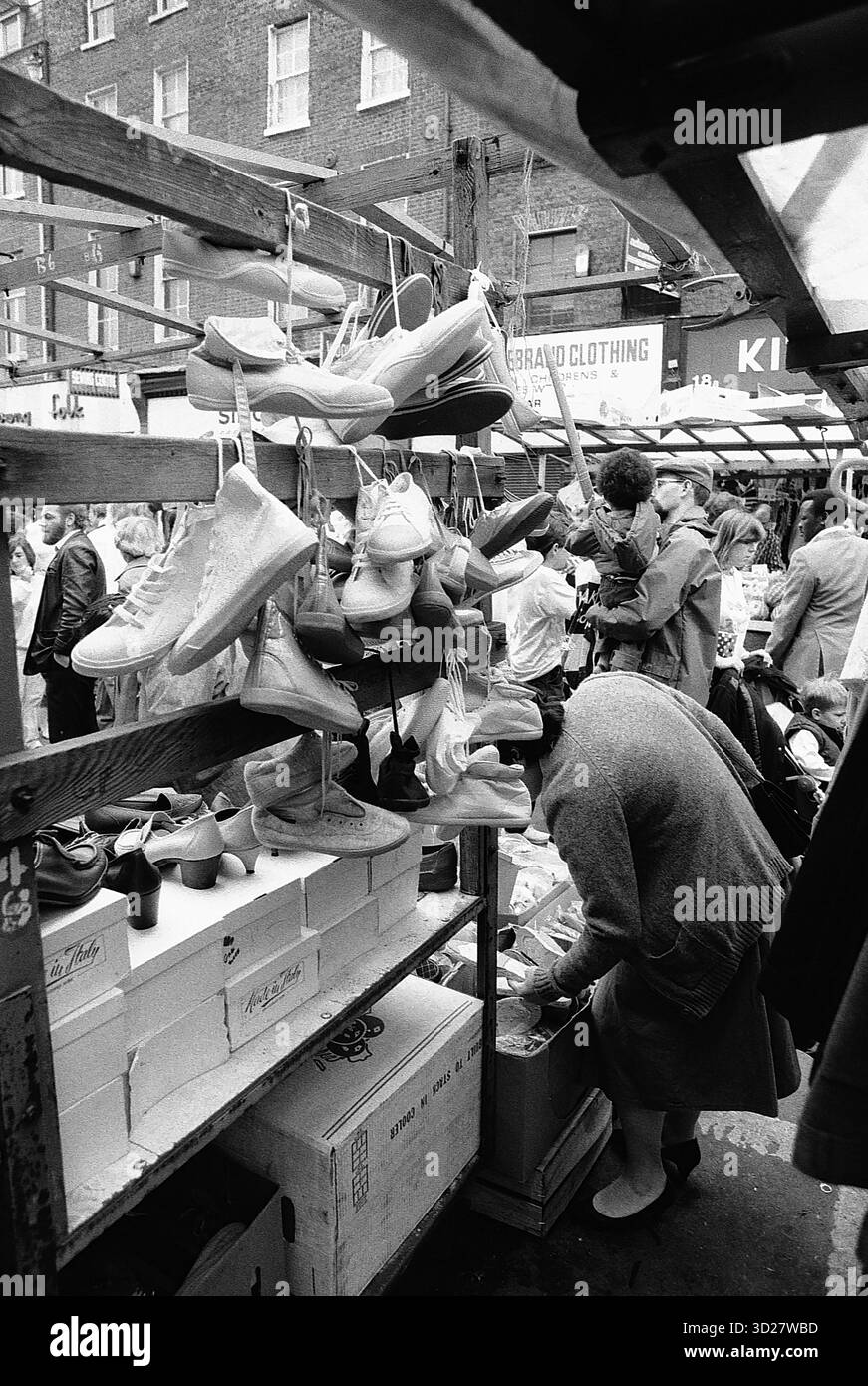 Mercato di Camden Lock: Un'istantanea della vivace vita urbana. Gli amanti dello shopping curiosano tra una variegata selezione di prodotti sotto gli iconici archi vittoriani di Camden Lock, un vivace centro di creatività e commercio nel cuore di Londra. Foto Stock
