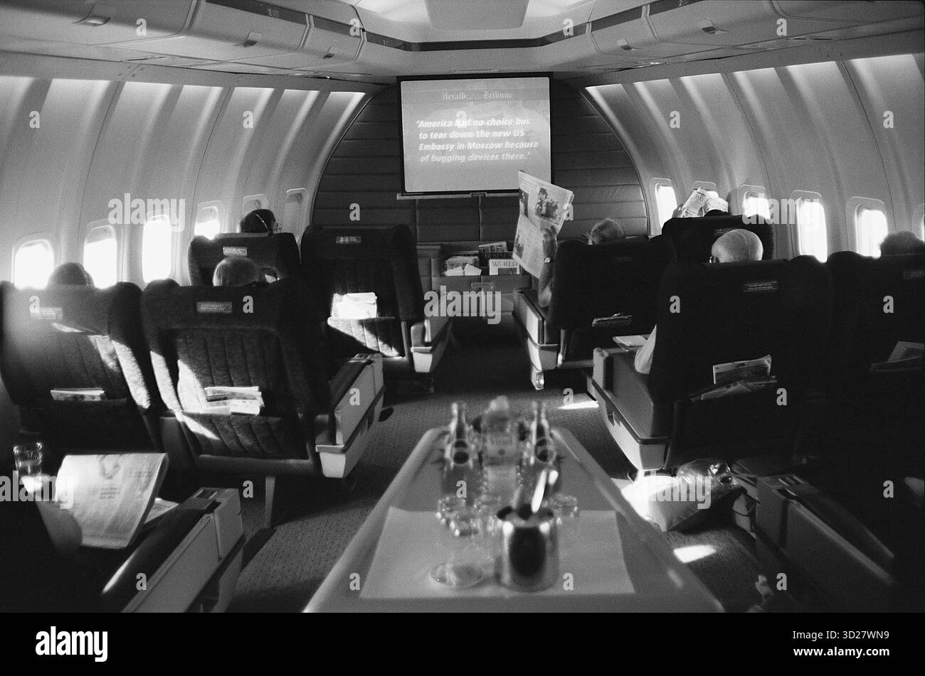 Un lussuoso sguardo al mondo di prima classe a bordo di un Boeing 747. I passeggeri si rilassano in lussuosi posti a sedere, gustando un pasto a bordo e l'intrattenimento all'interno della spaziosa cabina dell'aereo. La scena cattura l'esperienza di viaggio premium offerta da questo iconico jumbo jet. Foto Stock