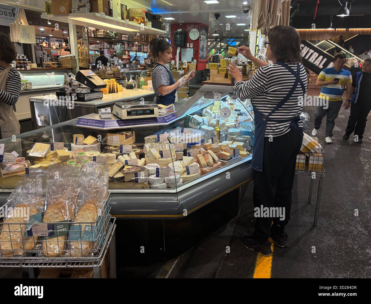 Il personale prepara i formaggi presso lo Smelly Cheese Co, Adelaide Central Markets, Australia meridionale. No MR o PR - Immagine stock catturata con smartphone