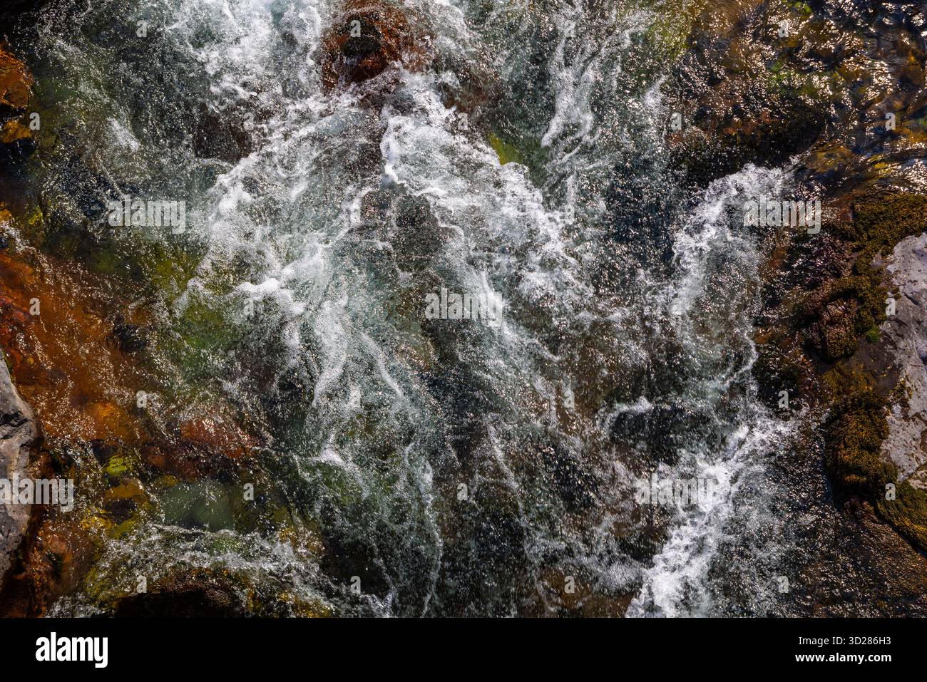 Fiume che scorre con rocce sommerse in un ambiente naturale, vista ad angolo alto Foto Stock