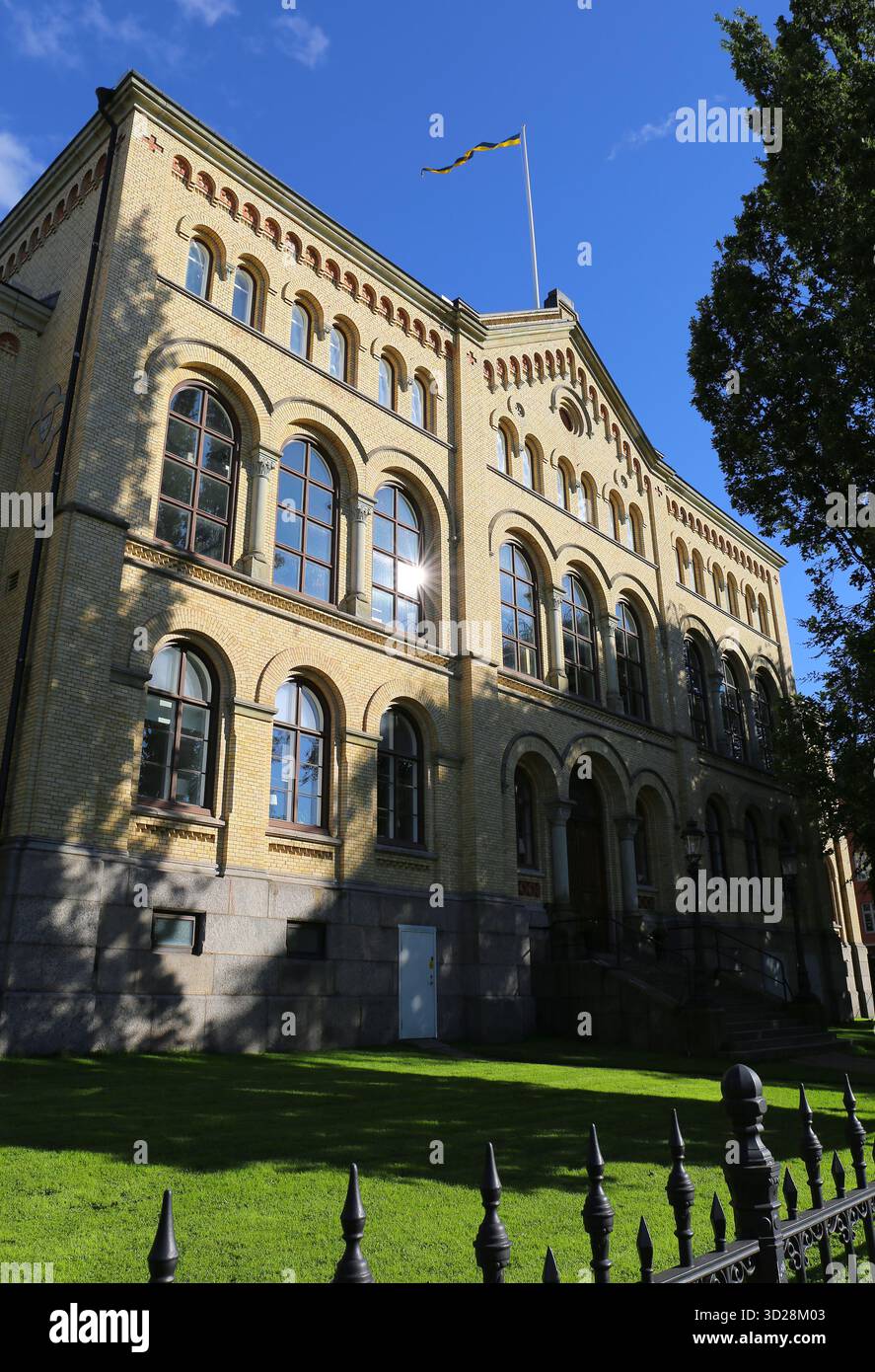 Edificio storico della scuola secondaria di Tingvallagymnasiet con recinzione, erba e cielo blu a Karlstad, Svezia Foto Stock