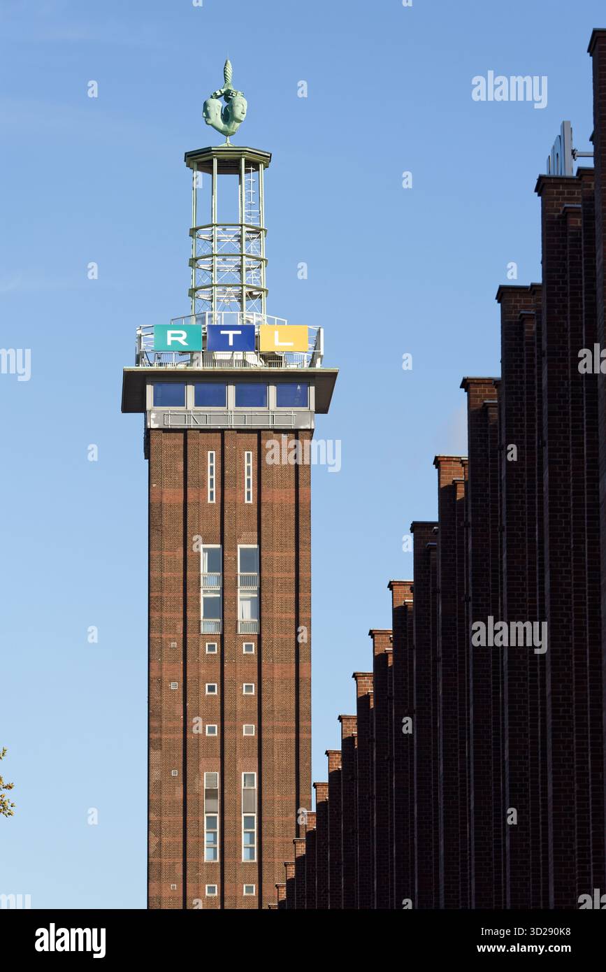 Colonia, Germania ottobre 30 2025: Messeturm storico in mattoni a Colonia-Deutz, sormontato dall'iconica scultura di Hermes (1928) e dalla moderna RTL Television si Foto Stock