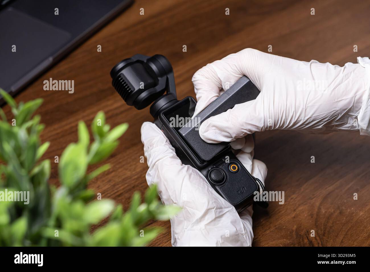 Poznan, Polonia - 16 ottobre 2025: La tasca DJI Osmo è preparata da una persona che indossa guanti in lattice bianco, fissando con attenzione un modulo schermo al prodotto in arrivo Foto Stock