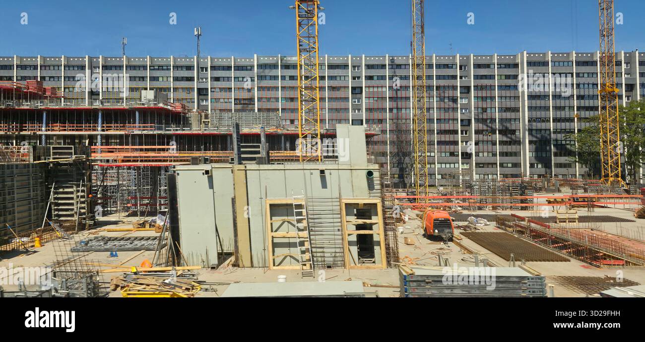 Berlino, Germania - 13 maggio 2025: Il cantiere presenta gru, strutture e macchinari sotto il cielo azzurro. Foto Stock
