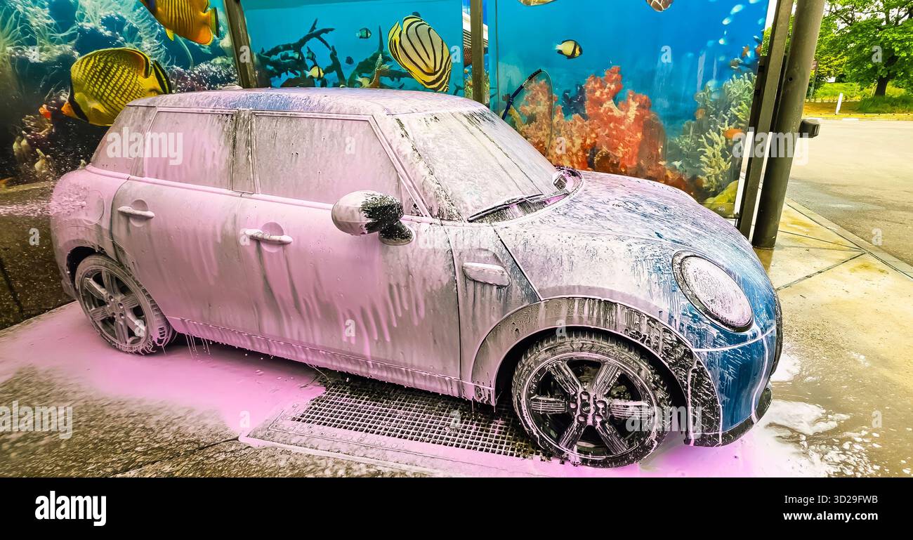 Berlino, Germania - 18 maggio 2025: Mini Cooper è ricoperta di schiuma al lavaggio dell'auto, con una vivace scena subacquea alle spalle. - Immagine stock catturata con smartphone