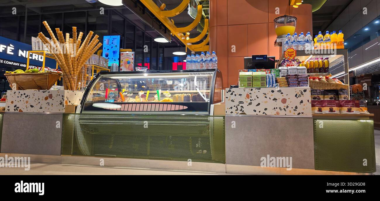 Doloman, Turchia - 25 aprile 2025: Moderna vetrina di caffe' con pasticceria colorata e bevande in un'atmosfera vivace. Foto Stock