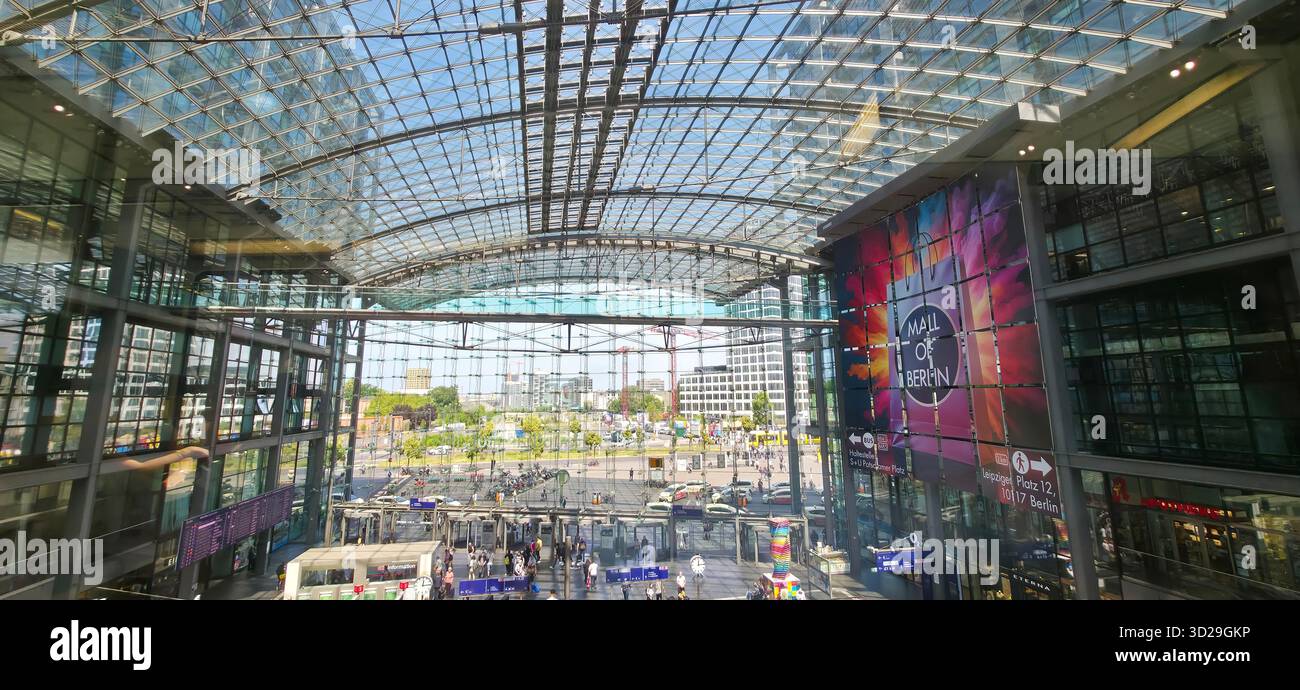 Berlino, Germania - 17 giugno 2025: Moderna struttura in vetro della stazione centrale di Berlino con opere d'arte colorate. - Immagine stock catturata con smartphone