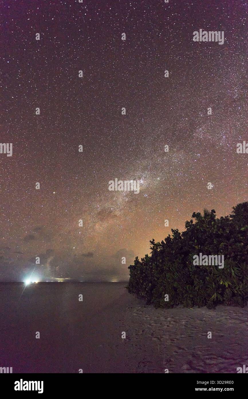 La via Lattea vista appena a nord dell'equatore, che si innalza attraverso il cielo sopra la spiaggia tropicale sull'isola di Havodda, l'atollo Gaafu Dhaalu, le Maldive. Foto Stock