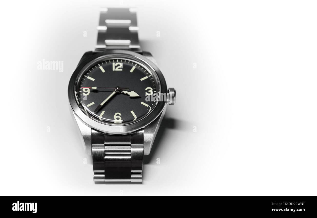 Orologio con quadrante nero su cassa in acciaio e bracciale con finitura satinata su sfondo bianco con morbide ombre Foto Stock
