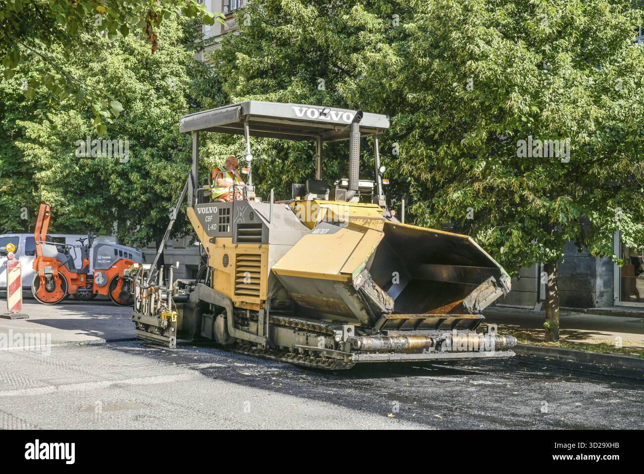 Costruzione di strade, asfaltatrice, break, conducente che dorme al volante, riga, Lettonia Foto Stock
