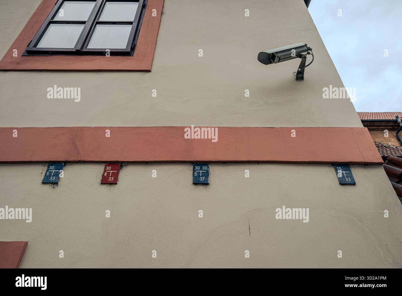 Edificio della città vecchia di Praga con idranti antincendio e piastre di segnalazione delle acque reflue e una telecamera a circuito chiuso, che rappresenta la sicurezza urbana europea e il sistema infrastrutturale Foto Stock