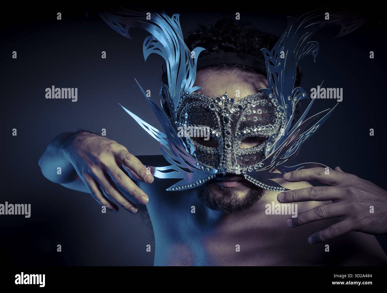 Uomo barbuto con maschera d'argento in stile veneziano. Mistero e rinascimento Foto Stock