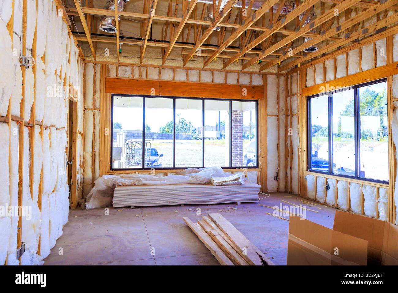 Interno edificio in costruzione inquadratura esposta, isolamento, pavimenti non finiti, utensili, materiali. Foto Stock