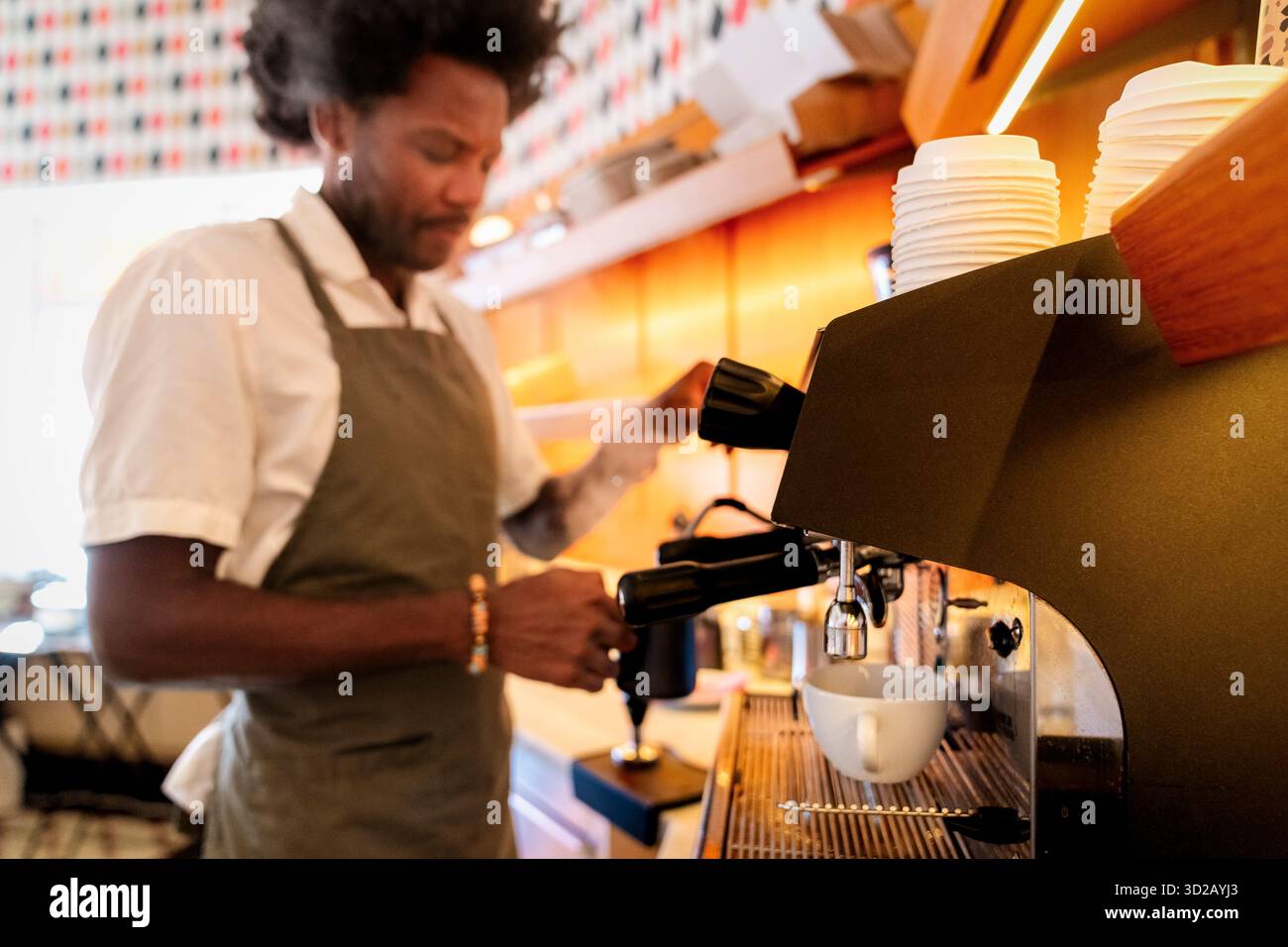 Macchina per il caffè con barista che lavora in background al bar Foto Stock