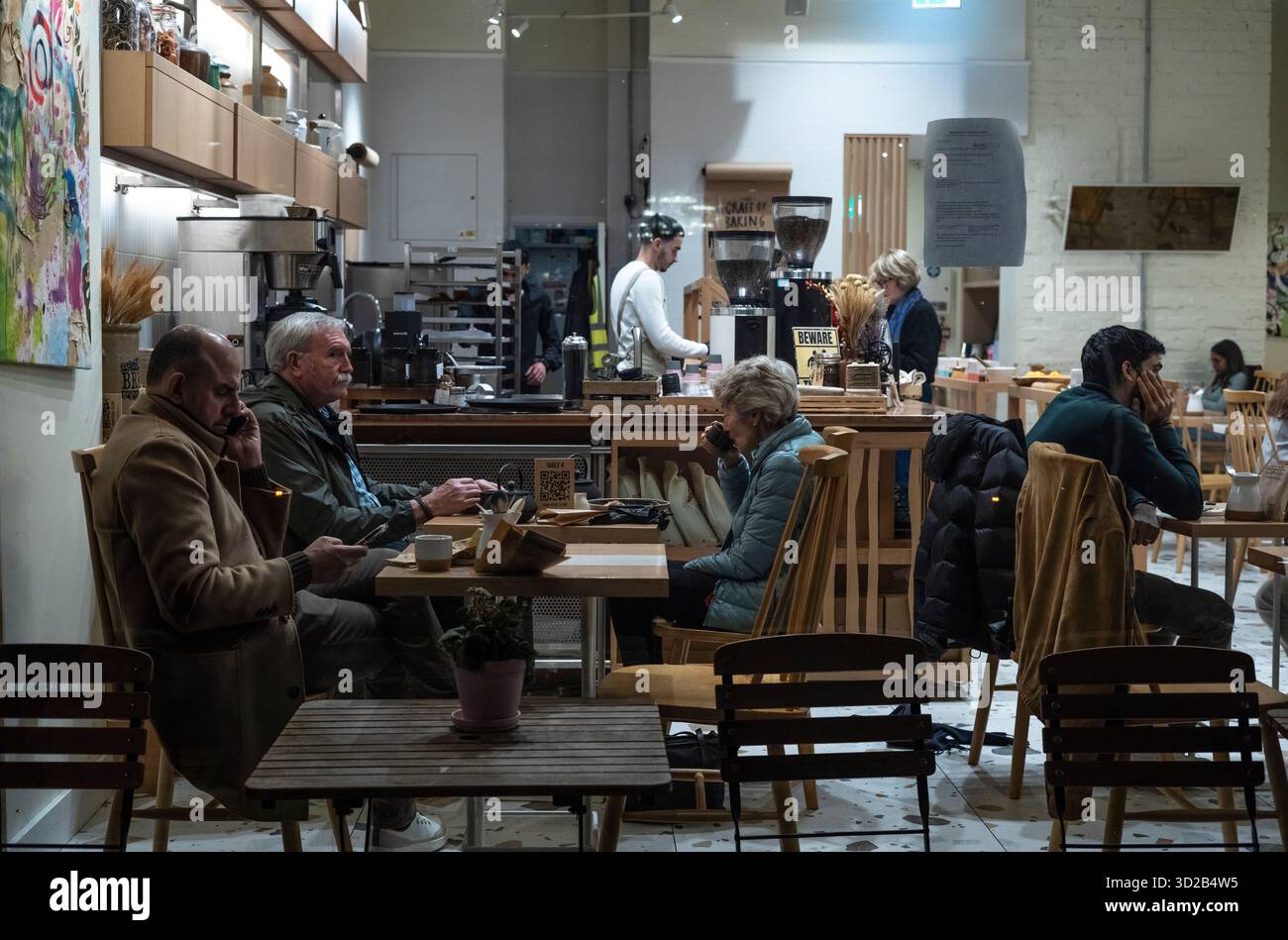 Le persone si siedono all'interno di un affollato caffè situato lungo Piccadilly, nel cuore di Mayfair, Londra, Inghilterra, Regno Unito Foto Stock