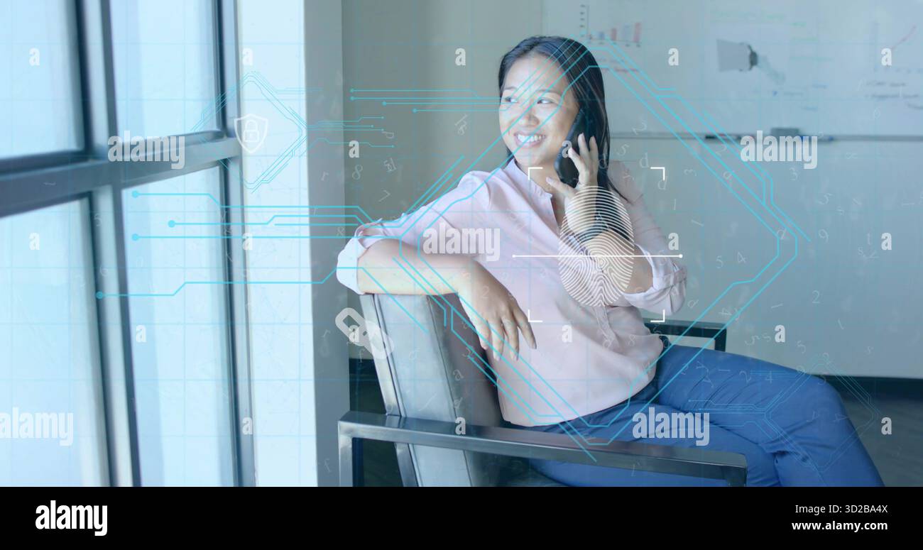 Donna parlante che indossa top rosa e jeans in salotto accanto alla finestra, con smartphone e sovrapposizioni digitali Foto Stock