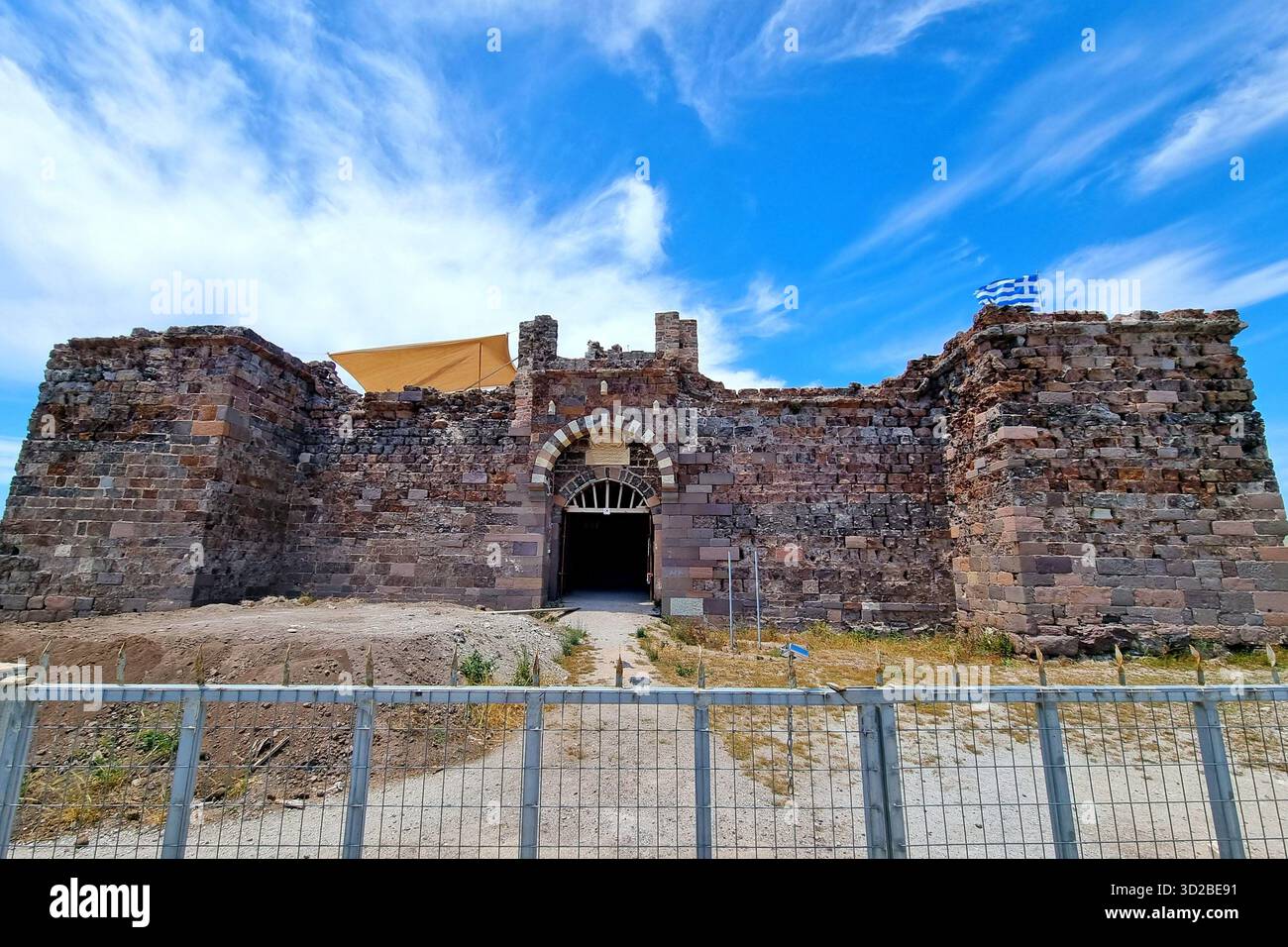 Vista dell'antico forte-castello ottomano realizzato in trachite marrone-rossa con bandiera greca nel piccolo villaggio di pescatori di Sigri sull'isola di Lesbo Foto Stock