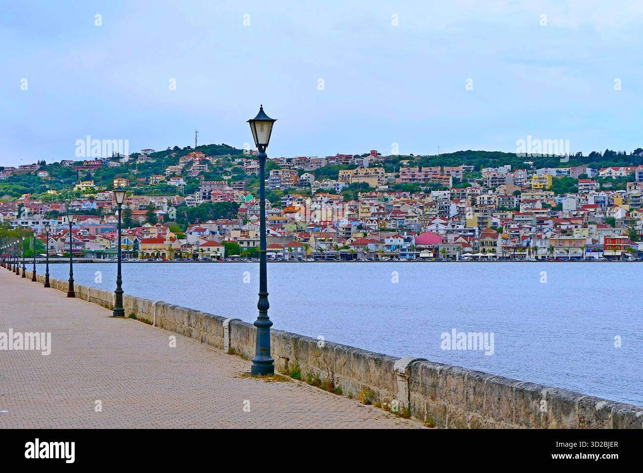 Lo storico Ponte De Bosset in pietra con i classici lampioni sullo sfondo di case colorate ad Argostoli, Cefalonia, Grecia Foto Stock