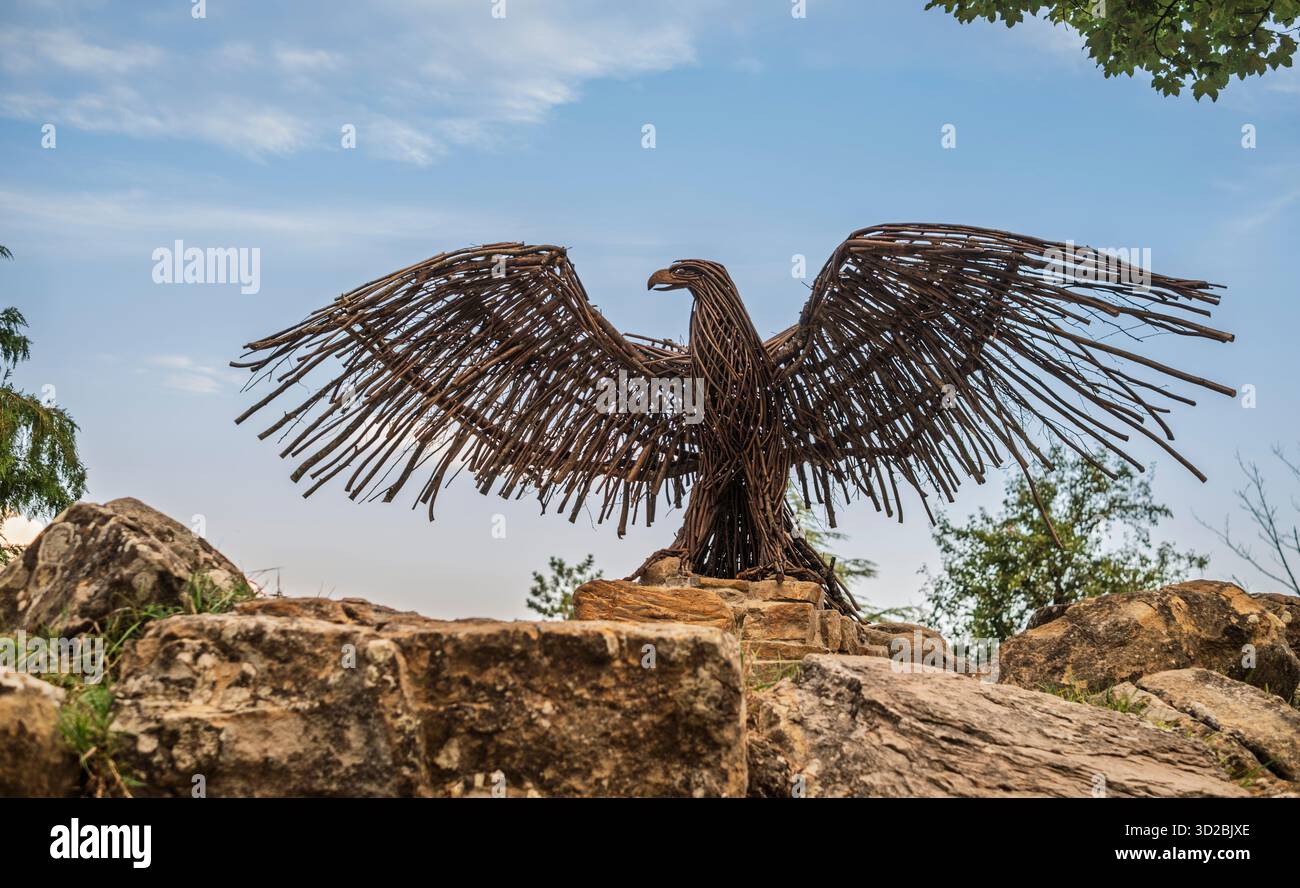 Una maestosa scultura di aquila, tessuta da rami naturali, si trova arroccata su rocce. Questa installazione Land Art di Simone Paulin si trova a Monghidoro, Bologna, Foto Stock