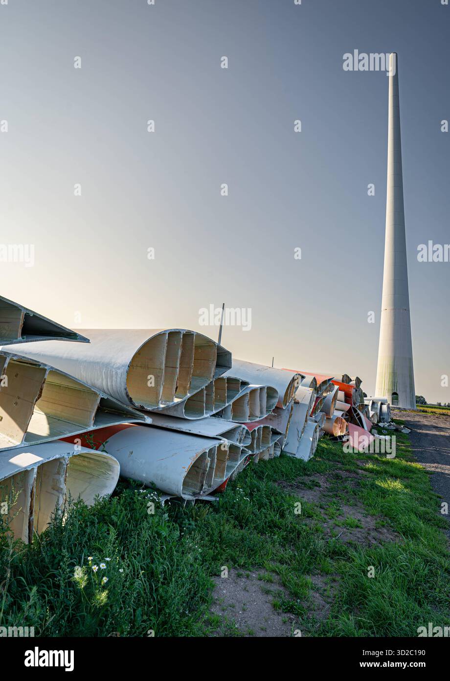 Windenergie - zerteilte Rotorenblätter eines Windrades warten auf ihren Abtransport zum Recycling, Hochformat. Entsorgung Alter Windrad-Rotoren im Rahmen einer repowering Maßnahme eines vorhandenen Windparks. Bevor neue, leistungsstärkere Winkraftanlage installiert werden können, müssen zunächst die Altanlagen weichen. Inder Praxis werden die Türme meist gesprengt , Die als Verbundstoffen bestehenden Rotoren werden in kleinere Stücke zerlegt und entsorgt. Es soll entsprechende Recycling-Verfahren zur Weiterverwendung der Materialien geben. Regione Weser-EMS Niedersachsen Deutschland *** vento Foto Stock