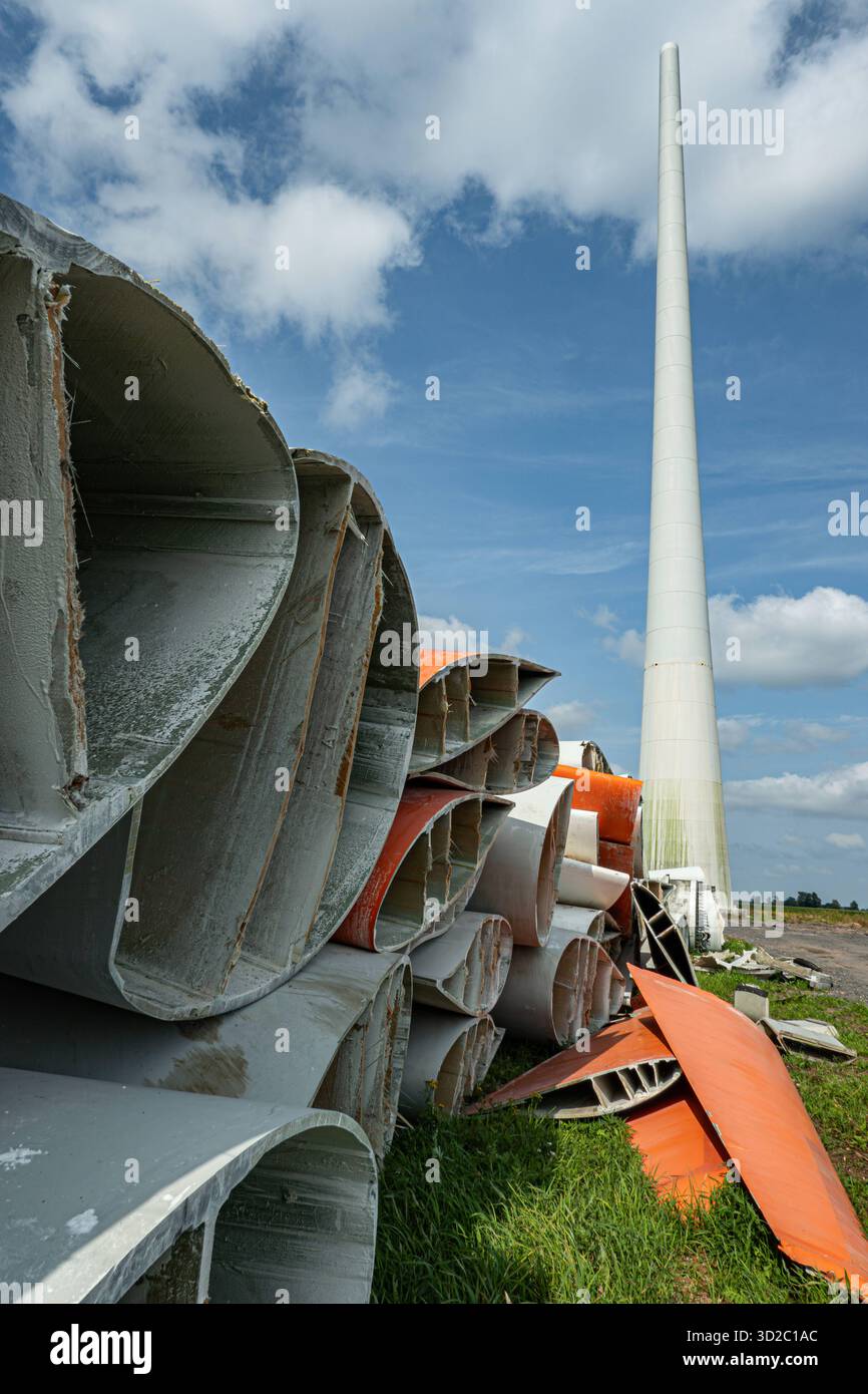 Windenergie - zerteilte Rotorenblätter eines Windrades warten auf ihren Abtransport zum Recycling, Hochformat. Entsorgung Alter Windrad-Rotoren im Rahmen einer repowering Maßnahme eines vorhandenen Windparks. Bevor neue, leistungsstärkere Winkraftanlage installiert werden können, müssen zunächst die Altanlagen weichen. Inder Praxis werden die Türme meist gesprengt , Die als Verbundstoffen bestehenden Rotoren werden in kleinere Stücke zerlegt und entsorgt. Es soll entsprechende Recycling-Verfahren zur Weiterverwendung der Materialien geben. Regione Weser-EMS Niedersachsen Deutschland *** vento Foto Stock