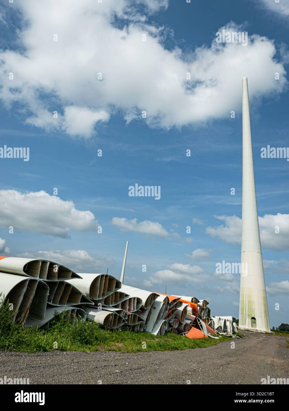 Windenergie - zerteilte Rotorenblätter eines Windrades warten auf ihren Abtransport zum Recycling, Hochformat. Entsorgung Alter Windrad-Rotoren im Rahmen einer repowering Maßnahme eines vorhandenen Windparks. Bevor neue, leistungsstärkere Winkraftanlage installiert werden können, müssen zunächst die Altanlagen weichen. Inder Praxis werden die Türme meist gesprengt , Die als Verbundstoffen bestehenden Rotoren werden in kleinere Stücke zerlegt und entsorgt. Es soll entsprechende Recycling-Verfahren zur Weiterverwendung der Materialien geben. Regione Weser-EMS Niedersachsen Deutschland *** vento Foto Stock