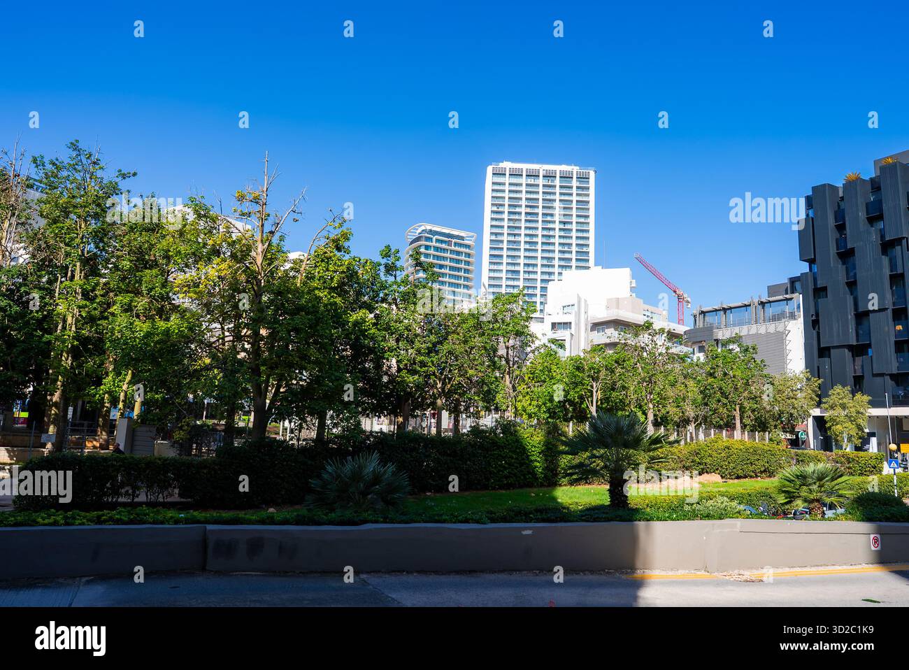 Moderni grattacieli e parco a Sliema, Malta, sotto la luce di mezzogiorno Foto Stock