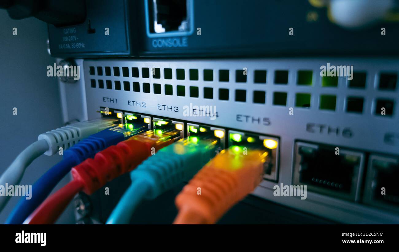 Cavi ethernet colorati collegati allo switch di rete, che simboleggiano il trasferimento dati ad alta velocità, la comunicazione sicura e le moderne tecnologie informatiche Foto Stock