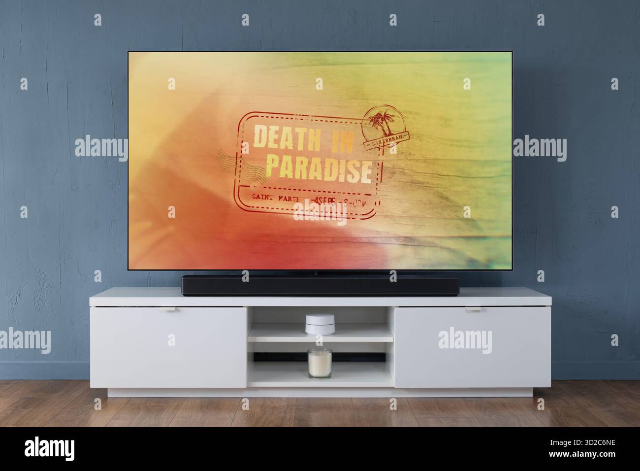 Un televisore OLED widescreen che mostra la scena introduttiva della serie TV Death in Paradise, visto in un salotto contemporaneo. Foto Stock
