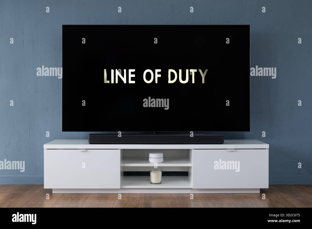 Un televisore OLED widescreen che mostra la scena introduttiva della serie TV Line of Duty, visto in un salotto contemporaneo. Foto Stock
