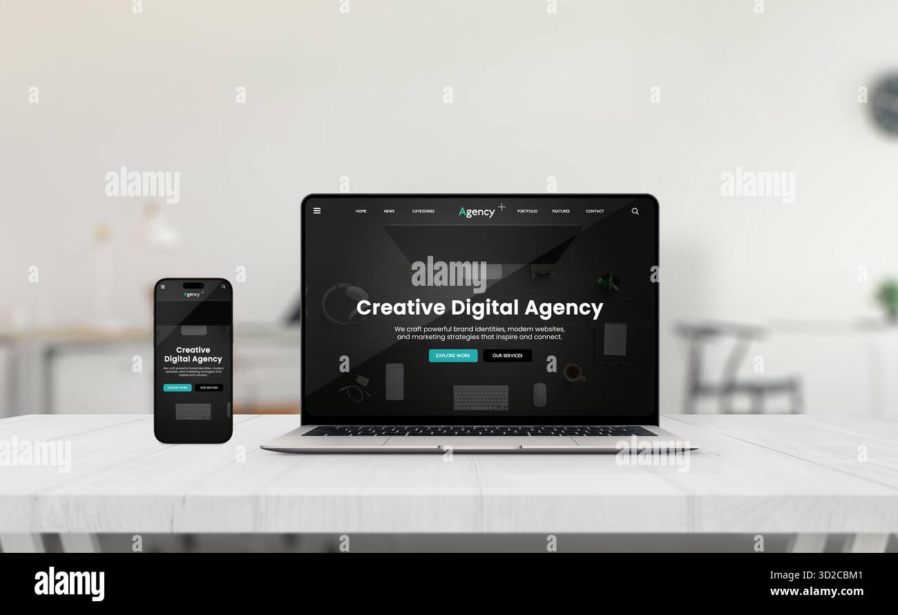 Laptop e smartphone che mostrano un'interfaccia reattiva per il sito Web dell'agenzia creativa su una scrivania luminosa in un elegante ufficio minimalista con sfondo neutro Foto Stock