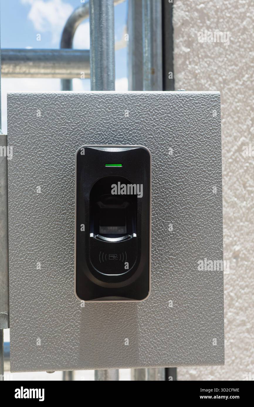 Dispositivo di controllo dell'accesso al lettore di impronte digitali e schede RFID installato all'esterno presso il cancello Foto Stock