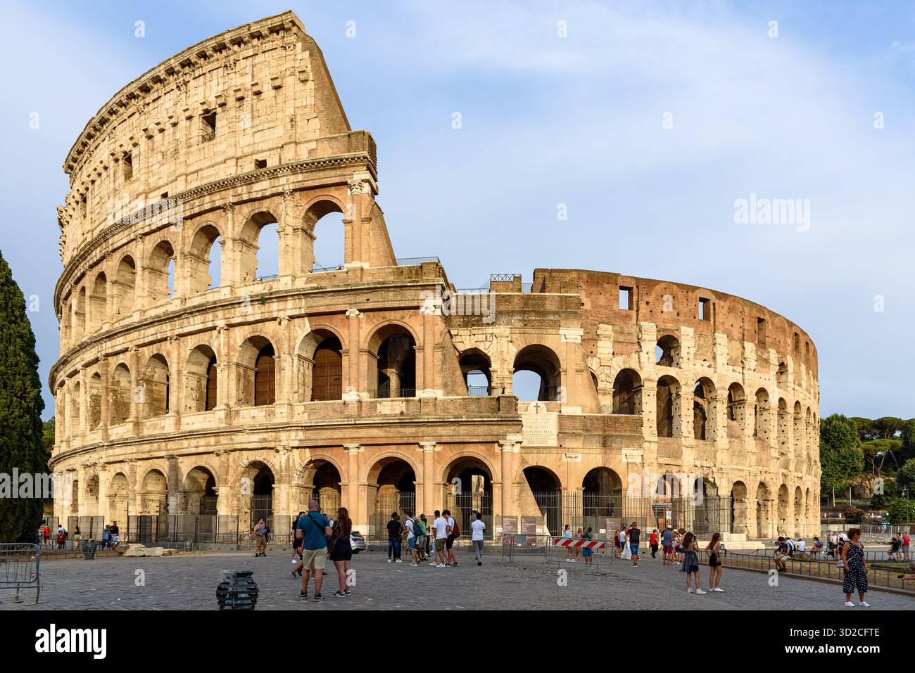 Il Colosseo di Roma con turisti che camminano nel tardo pomeriggio Foto Stock