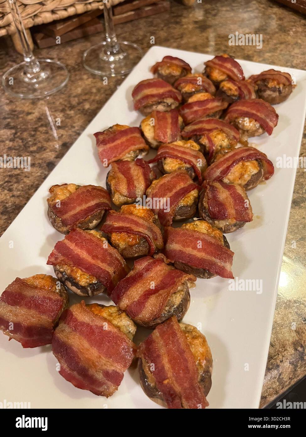 Funghi al forno con formaggio avvolto nella pancetta su un piatto quadrato bianco - Immagine stock catturata con smartphone