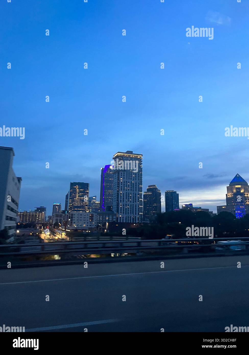 Vista serale del quartiere residenziale di Charlotte con l'autostrada e le luci della città - Immagine stock catturata con smartphone