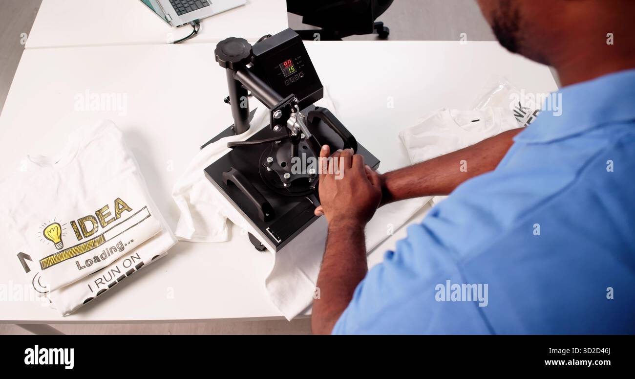 Creazione di progetti di T-shirt personalizzati utilizzando la pressa termica e il trasferimento dello schermo. Professioni possibili: Designer grafico Foto Stock