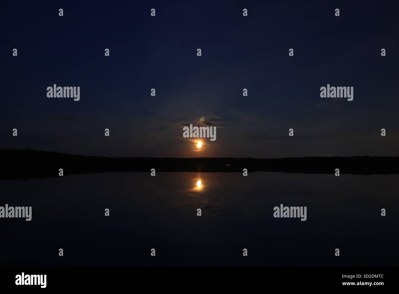 Superficie tranquilla del lago notturno con paesaggio lunare. Esposizione lunga. Foto Stock