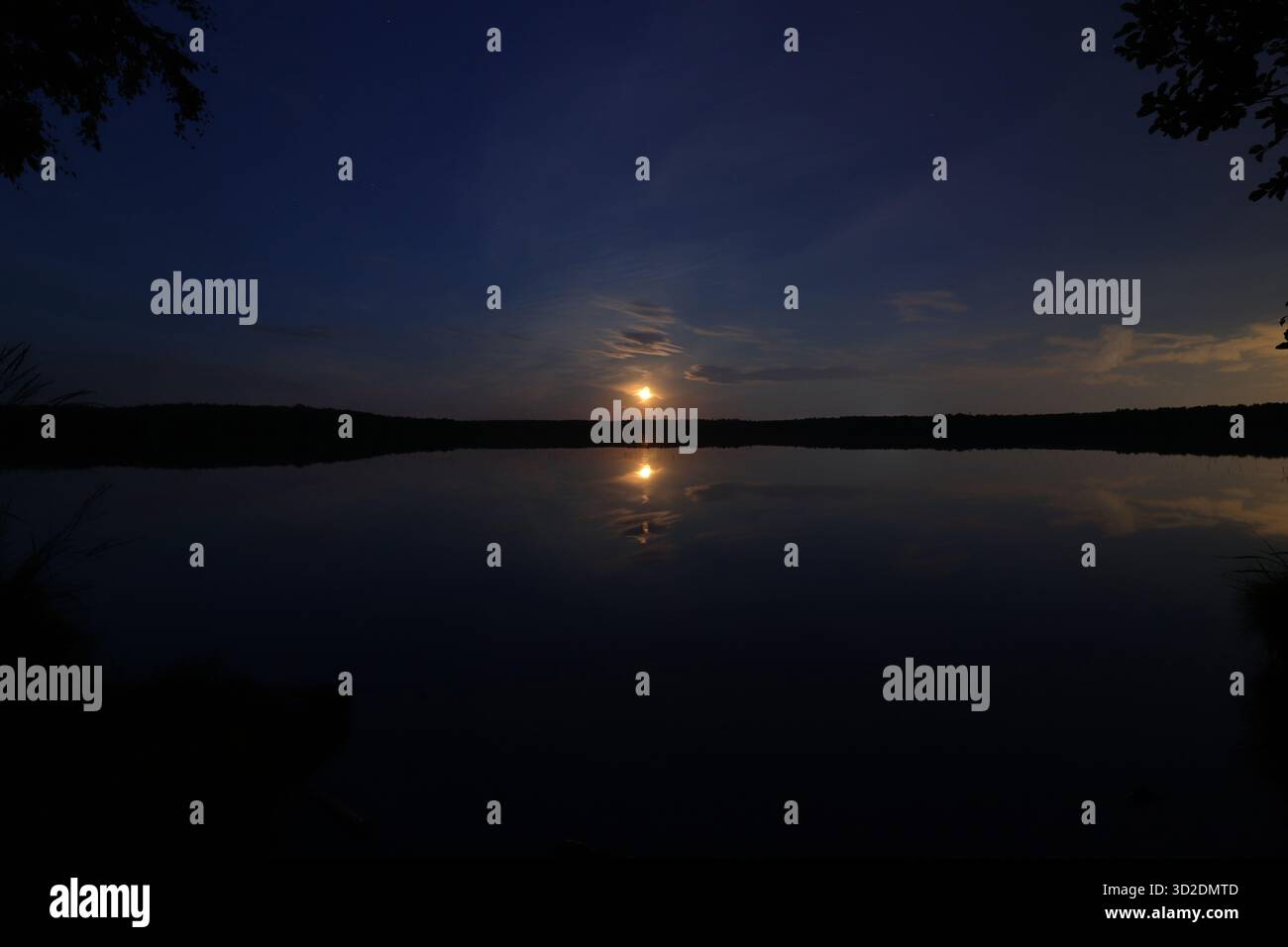 Superficie tranquilla del lago notturno con paesaggio lunare. Esposizione lunga. Foto Stock